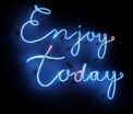 Bright blue neon sign with the phrase 'Enjoy Today' on a dark background, creating a vibrant and uplifting atmosphere.